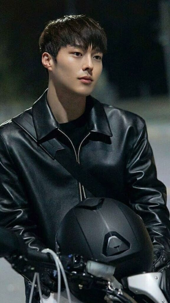 Aktor drama Korea Jang Ki Yong mengenakan jaket kulit hitam sambil memegang helm motor dengan ekspresi serius di malam hari