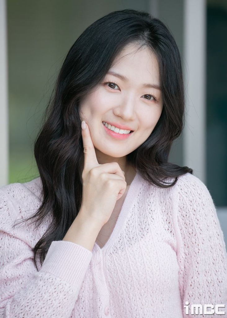 kim hye yoon dengan senyum yang cerah dan pakaian berwarna putih